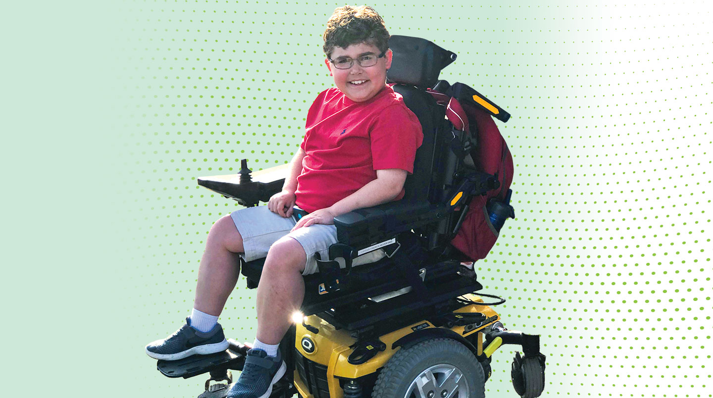 Ethan LyBrand smiles in his motorized wheelchair.