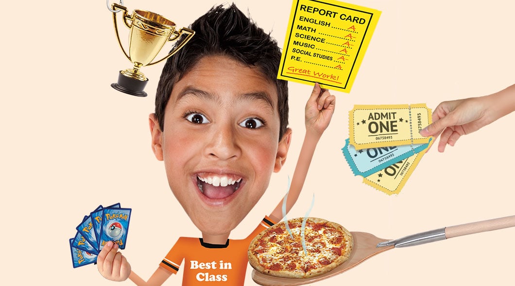 A smiling boy surrounded by a trophy, report card, admission tickets, trading cards, and pizza